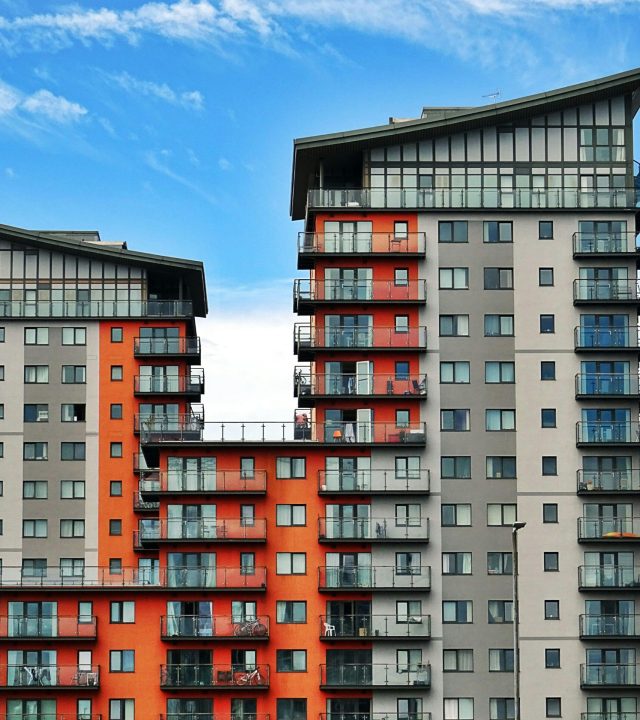 pexels-photo-439391-439391 Modern high-rise apartment buildings with unique architecture under a vibrant blue sky.